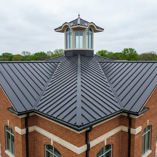 Standing seam metal roof with cupola on a commercial brick building in Carrollton, Dallas County, TX