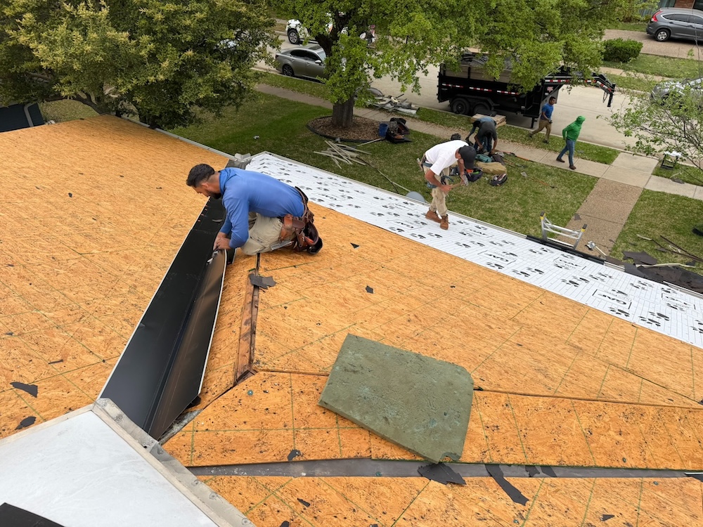 Roofers installing synthetic underlayment and drip edge flashing on new roof decking in Richardson Texas