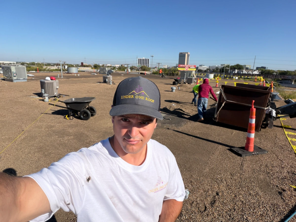 Max Wensinger of Under One Roof on a commercial roof replacement in Dallas, Dallas County, TX, with crew removing gravel from an existing built-up roof.