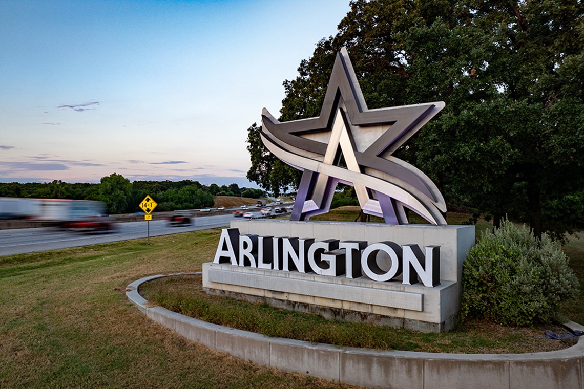 Arlington Texas star monument and city sign at dusk along the highway in Tarrant County, TX