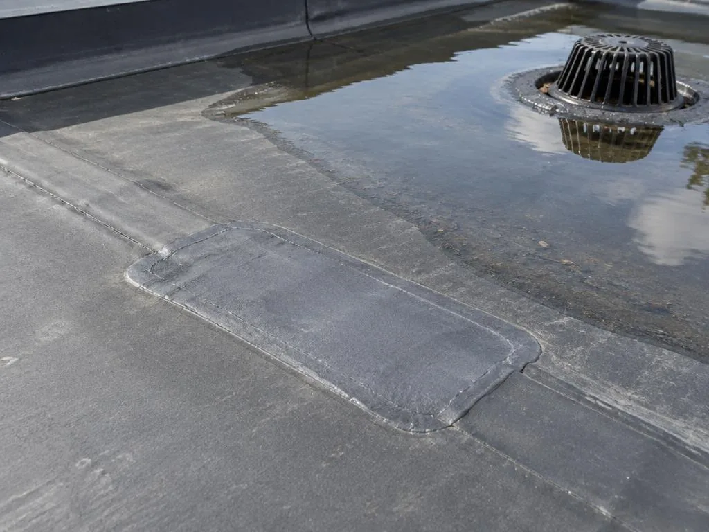 Flat roof repair at a seam and drain on a Carrollton commercial roof