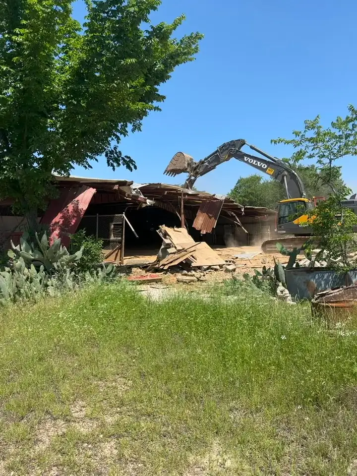 Building Demolition Farmers Branch: Excavator pulling down the last section of a building Excavator pulling down the last section of a building