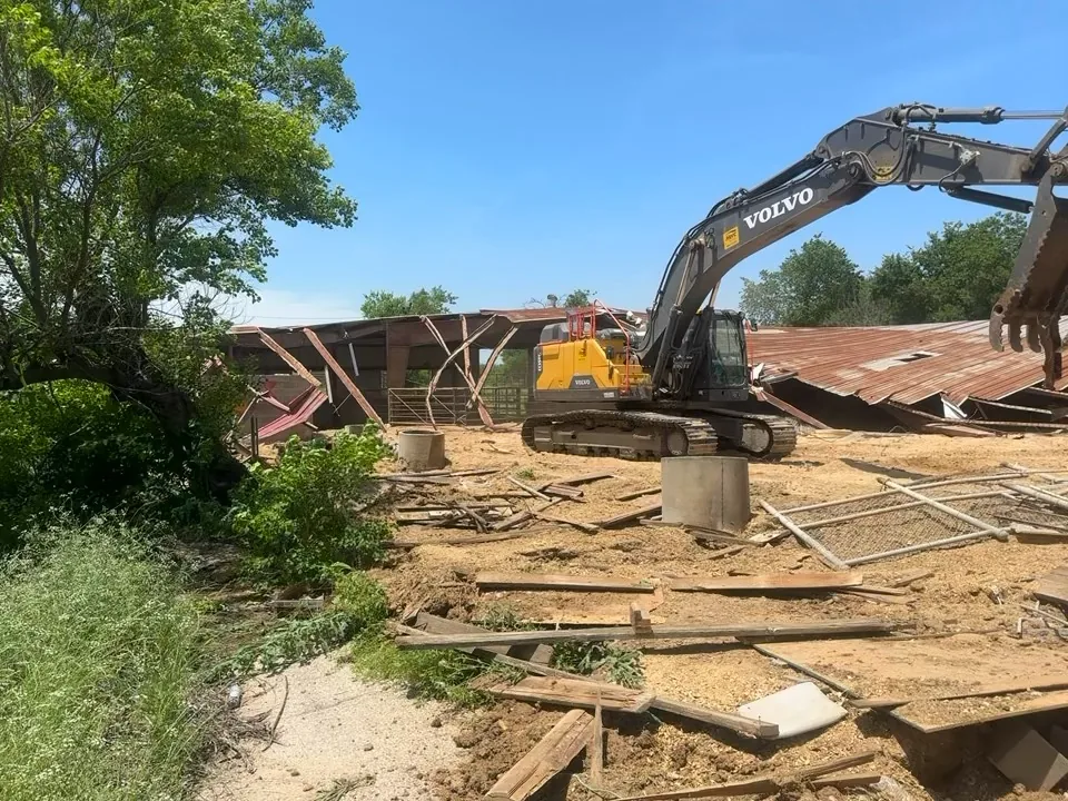 Excavator working through metal roofing and framing during a commercial demolition