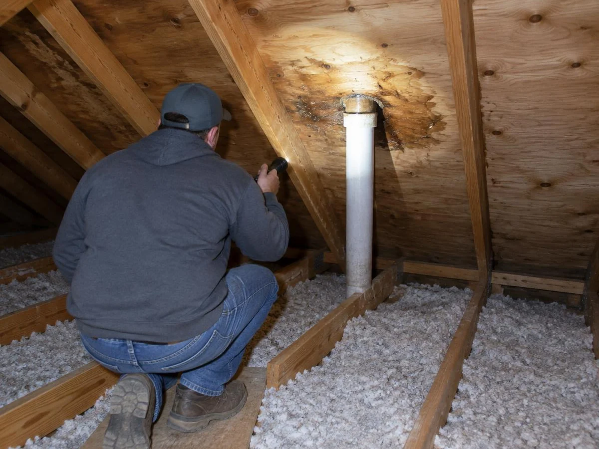 Roofer tracing a roof leak from the attic in a Farmers Branch, TX home