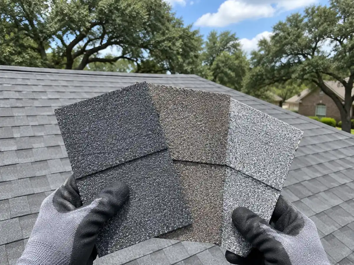 Roofer holding three shingle samples on a roof in Farmers Branch, TX