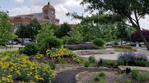 Lewisville Texas civic center building with beautiful landscaping and flower gardens, representing the well-maintained community served by Under One Roof home services