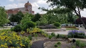 Lewisville Texas civic center building with beautiful landscaping and flower gardens, representing the well-maintained community served by Under One Roof home services