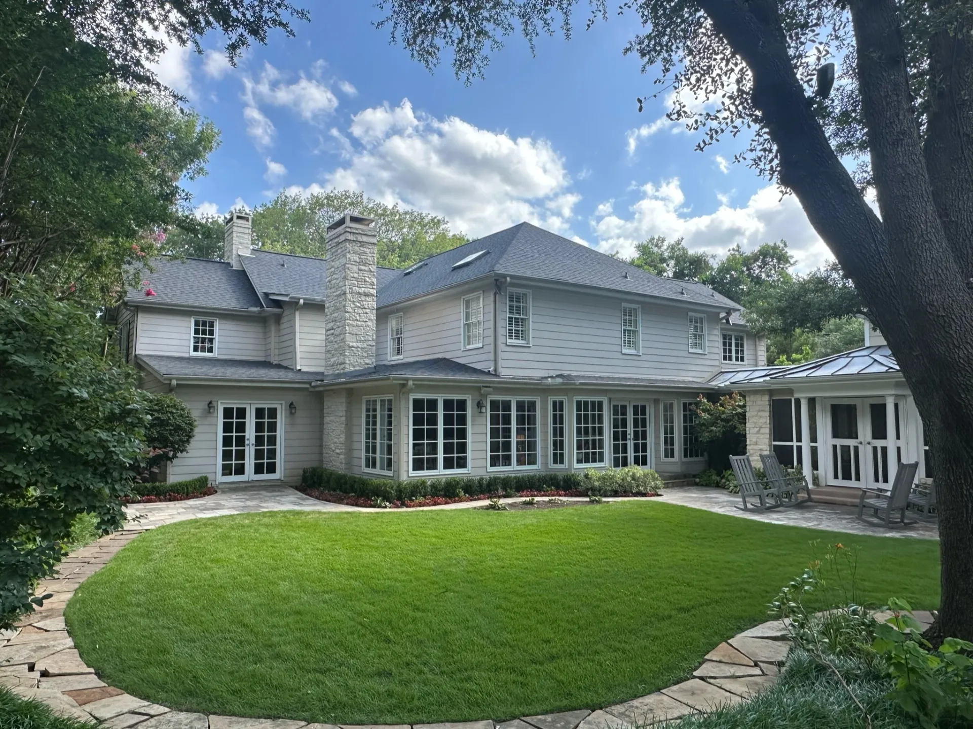 Two-story home in Highland Park, TX with new siding and shingle roof installation completed