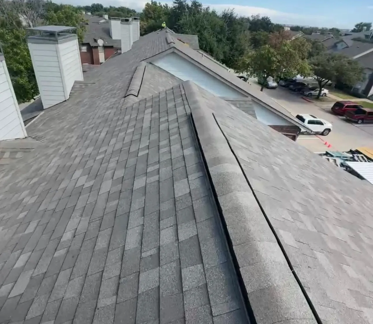 New shingle roof installation in Dallas, TX showing completed replacement shingles on a residential townhouse building
