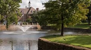 Scenic University Park Texas lake view with historic buildings and mature trees representing the prestigious residential community served by Under One Roof home services