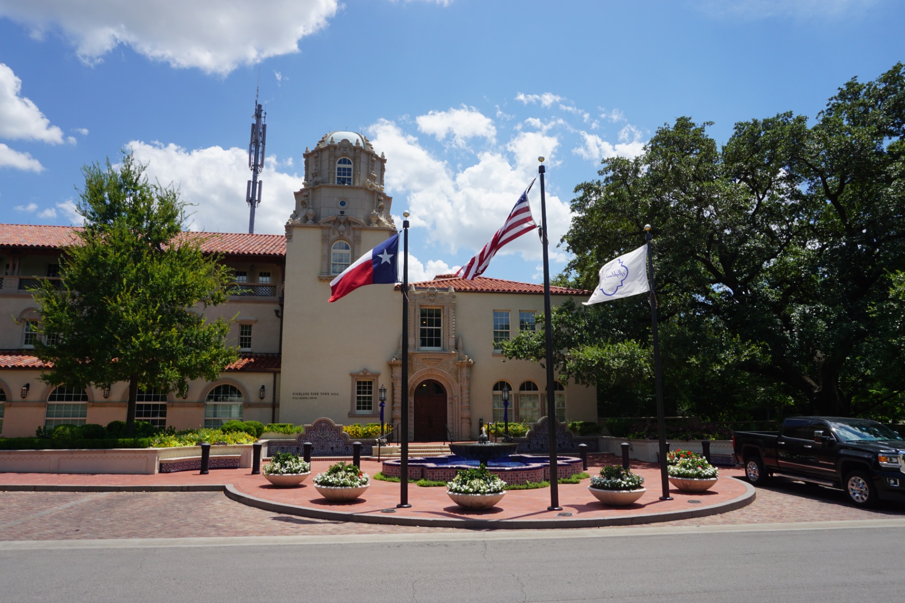 Highland Park Texas city hall building with Texas and American flags, representing the prestigious Park Cities community served by Under One Roof luxury home services