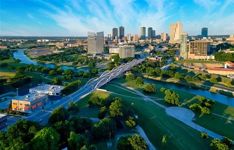 Fort Worth Texas downtown skyline aerial view with Trinity River and green parkland in foreground, showcasing the vibrant city served by Under One Roof roofing and home services