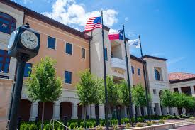 Colleyville Texas civic center and city hall with American and Texas flags, modern municipal building representing community pride and civic excellence - Under One Roof roofing and home services coverage area