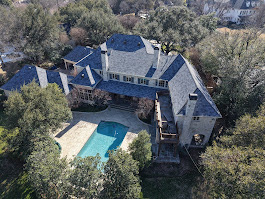 Aerial view of a Plano, TX home with a pool after new roof installation, featuring completed shingle roofing in excellent condition