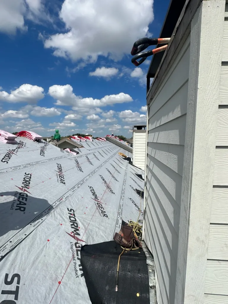 Multi-unit residential roofing and siding project in Dallas area, professional installation of underlayment on townhouse development with white siding