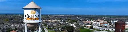 Celina Texas iconic water tower at sunset with city skyline and community development, symbol of growing town heritage - Under One Roof roofing and home services coverage area