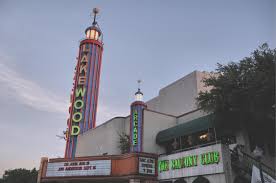 Historic Lakewood Theater in Dallas with classic neon marquee sign at dusk, representing the cultural heart of the Lakewood neighborhood served by Under One Roof home services